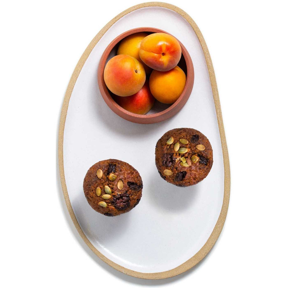 Best vegan pumpkin dark belgian chocolate muffins with pumpkin seeds served with fresh apricots on a plate made by Julie York, local artist from Vancouver, BC.